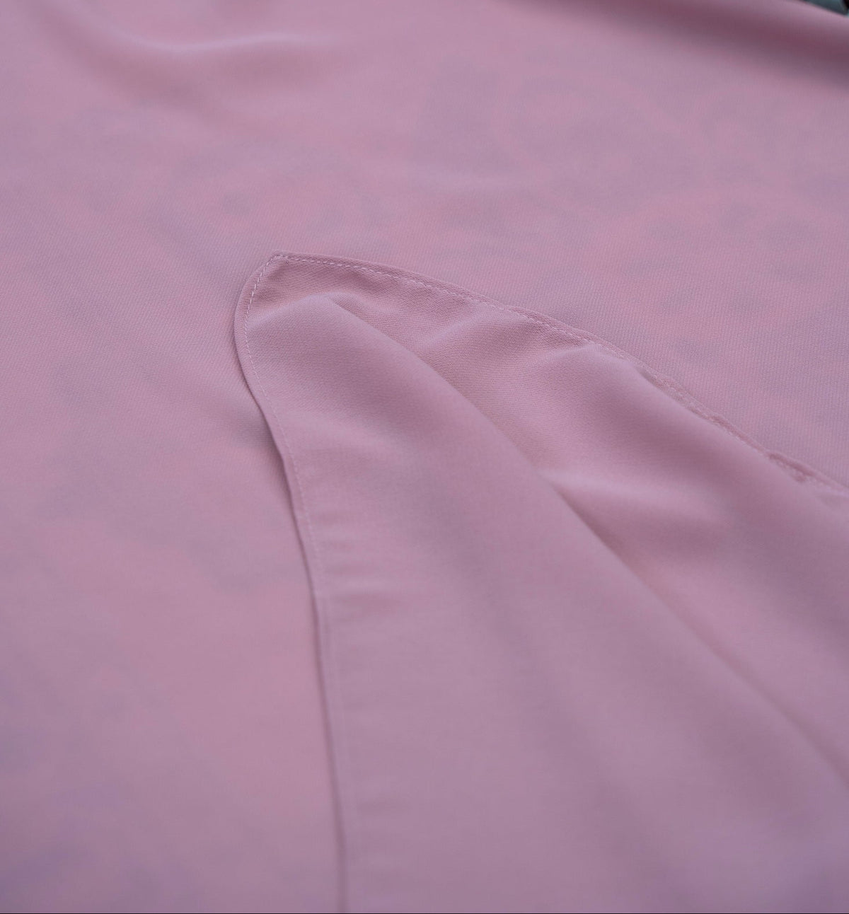 Close-up of pink satin fabric with a floral arrangement on top