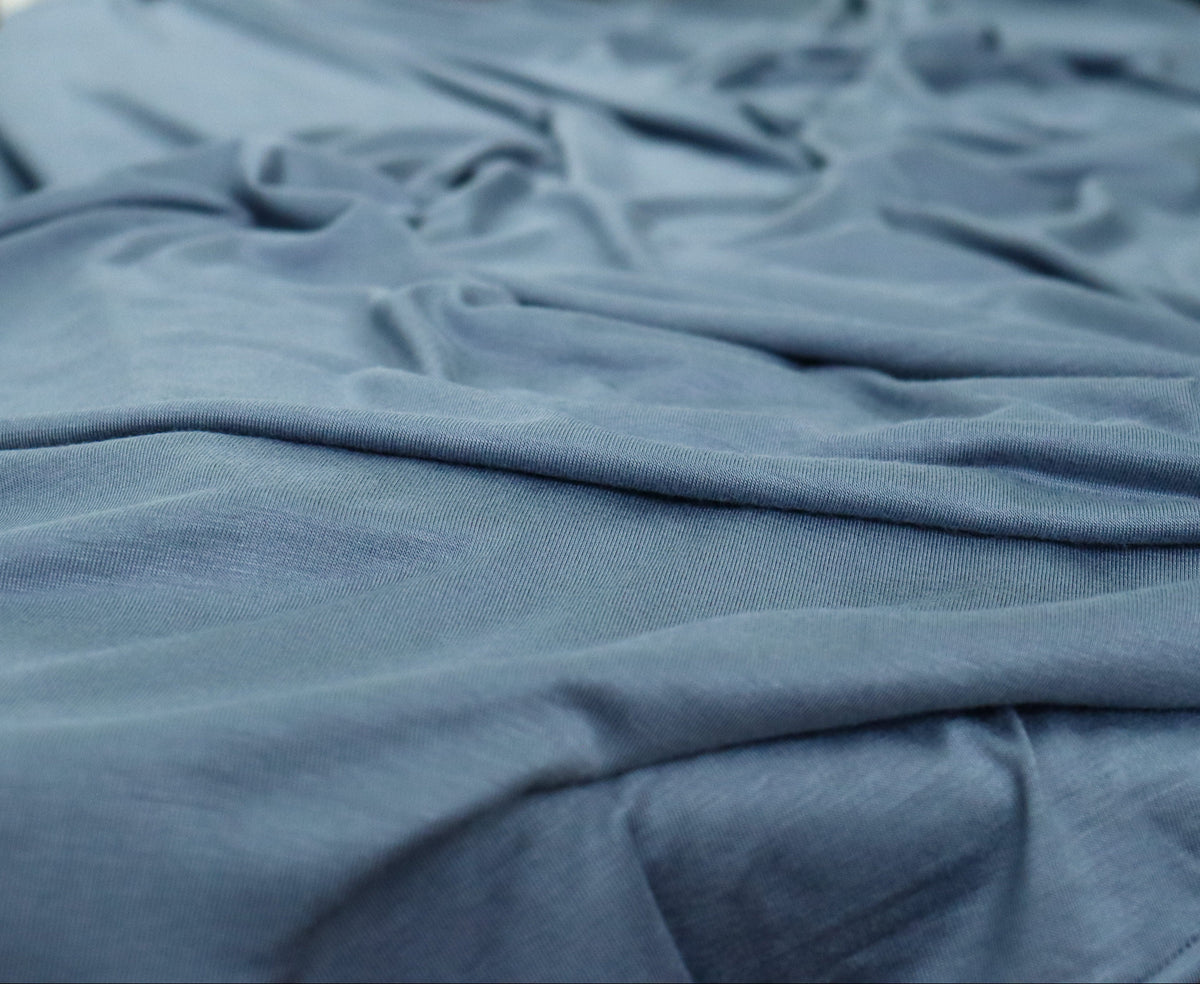 Blue fabric on a table with flowers in the background