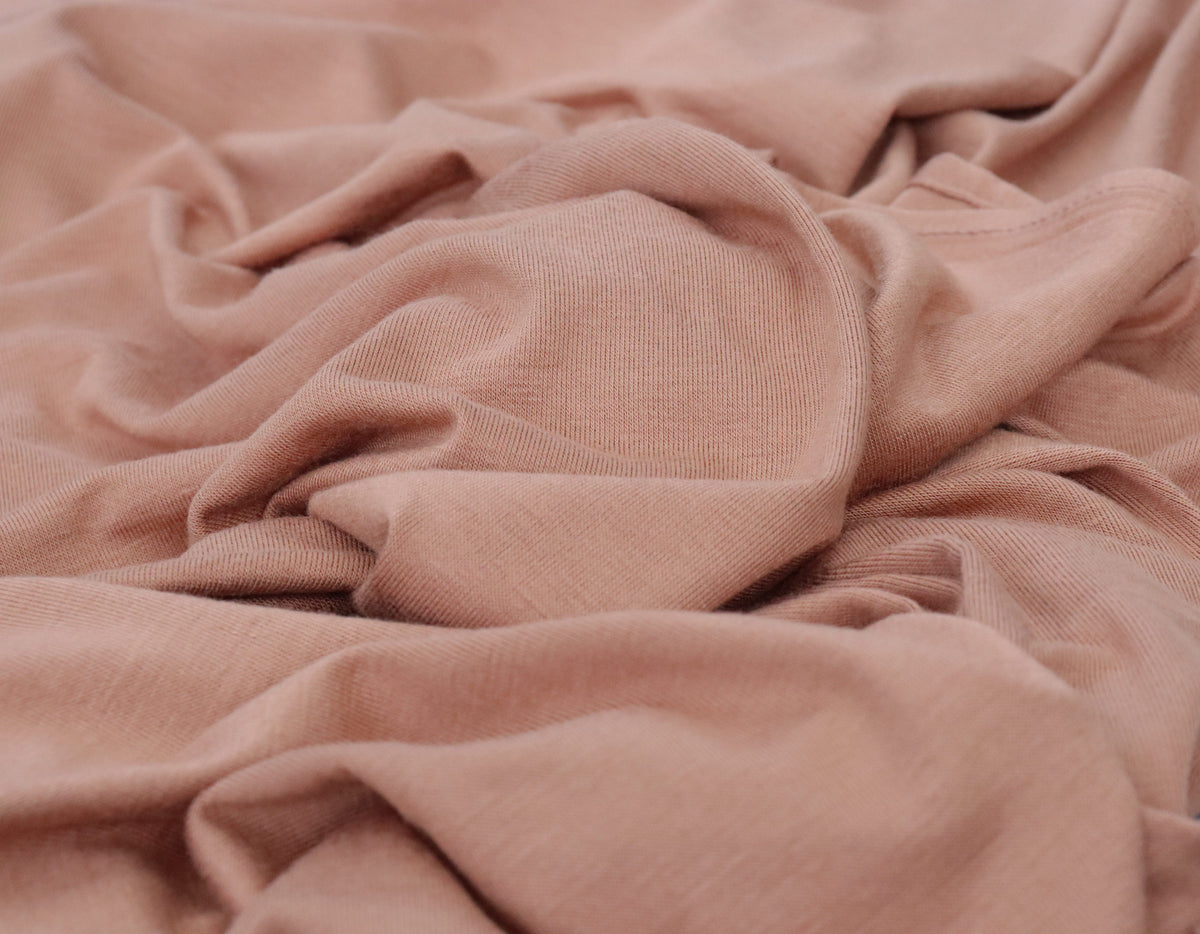Close-up of a textured pink fabric with folds