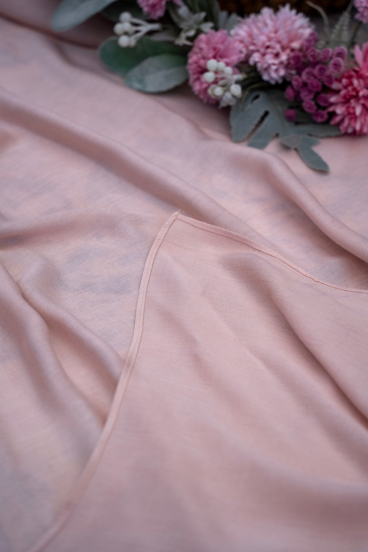 Close-up of a pink fabric with a floral arrangement on a soft pink background
