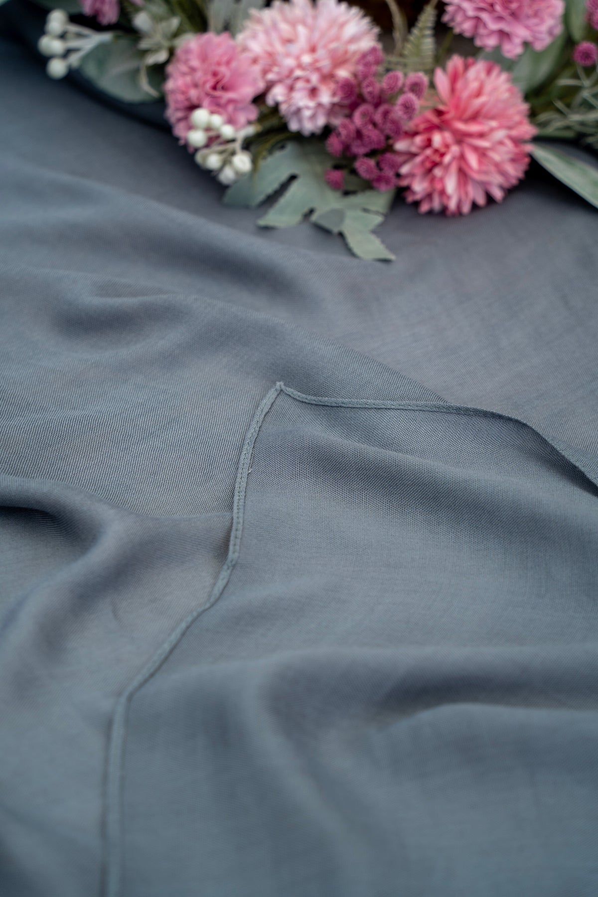 Gray fabric with a floral arrangement in the background