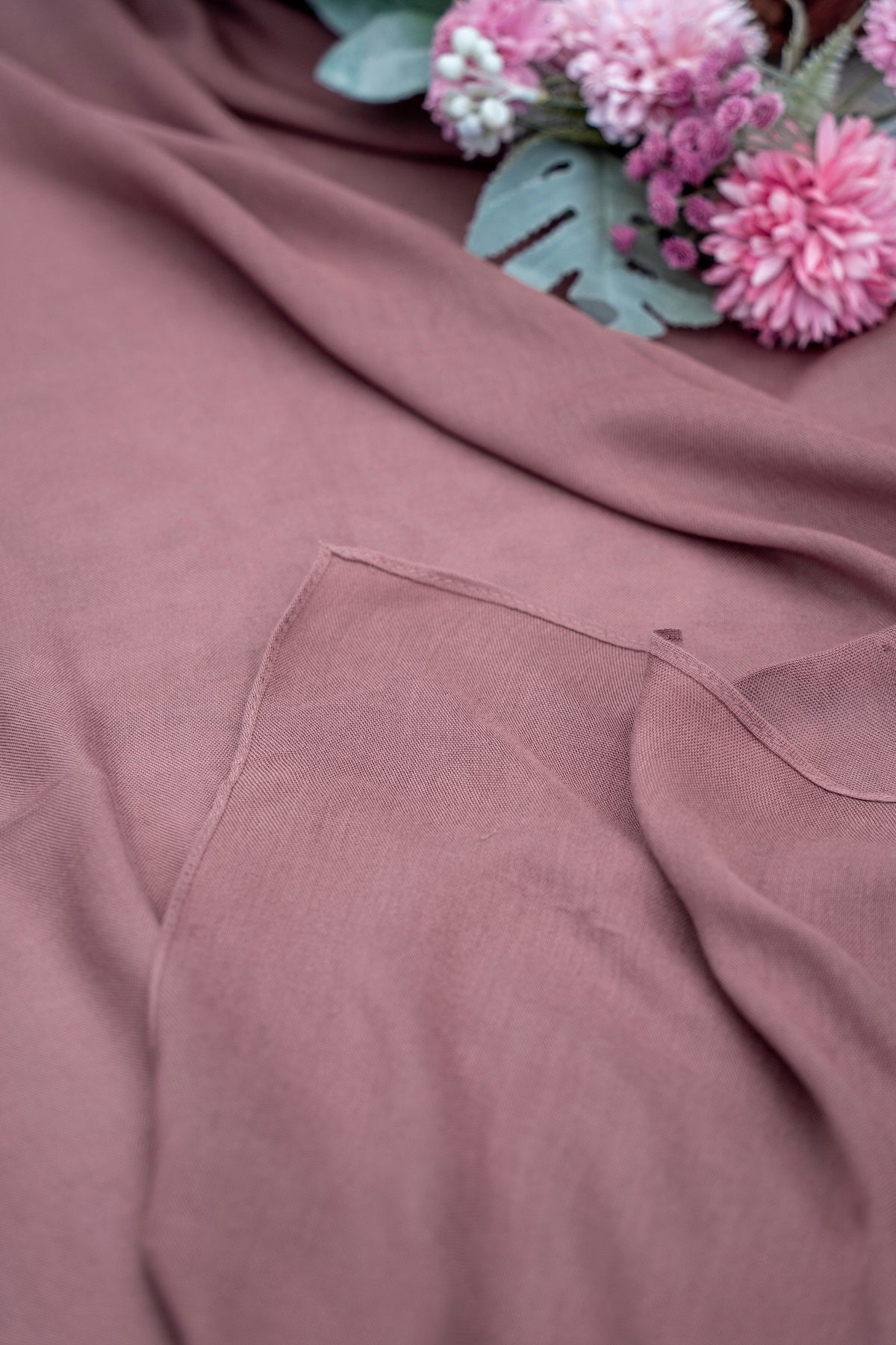 Pink fabric with a floral arrangement in the background