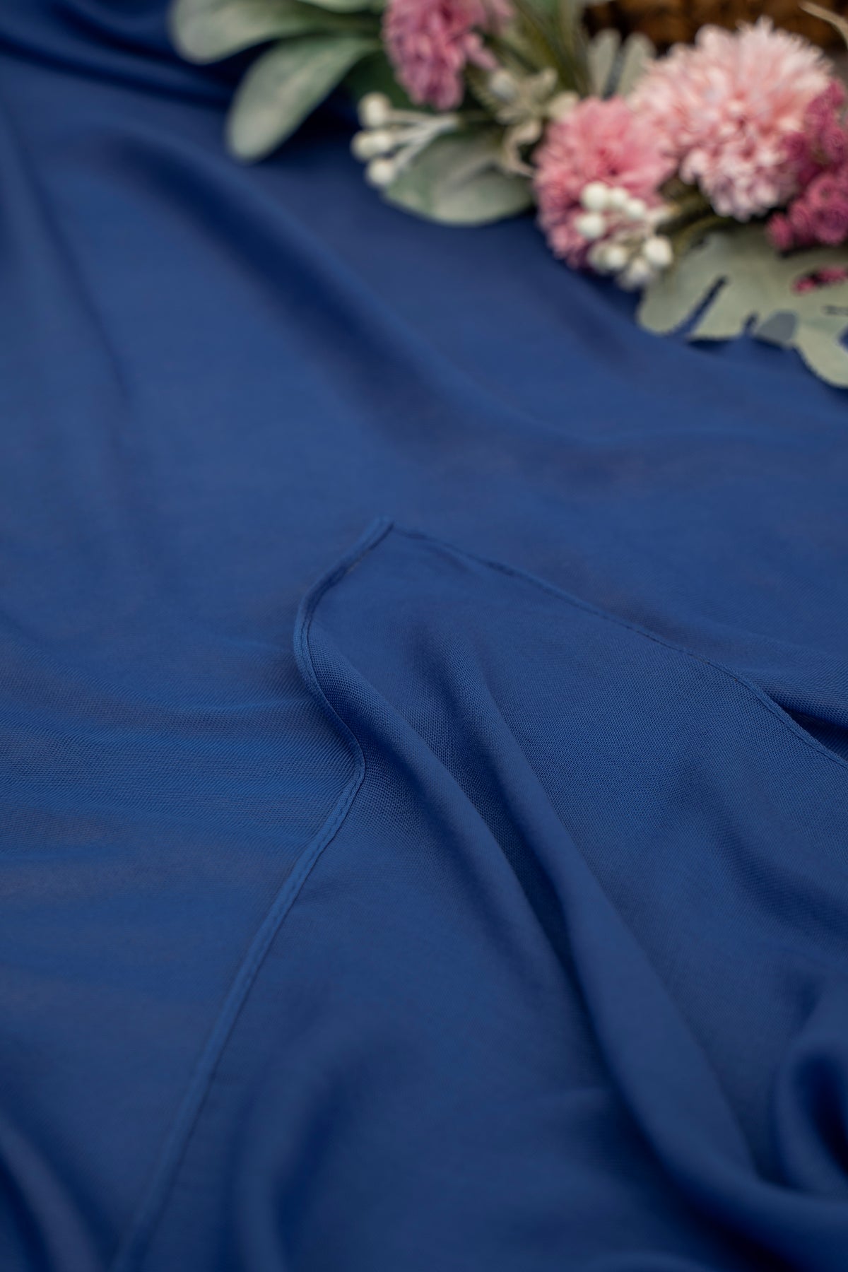Blue fabric with a floral arrangement in the corner