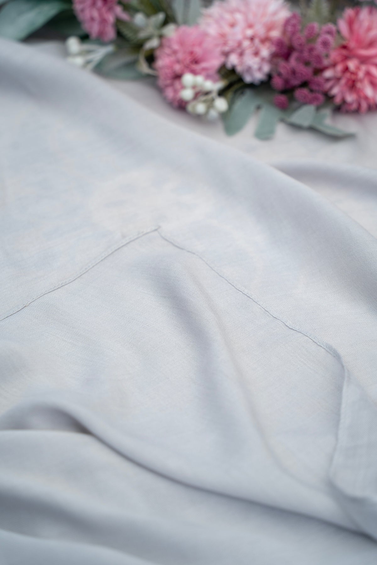 Gray fabric with a floral arrangement in the background