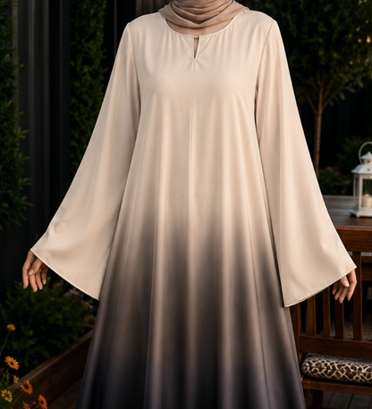 A woman wearing a long-sleeved modest dress with a beige-to-dark-gray ombre gradient, paired with a matching beige hijab, set against a dark garden background.
