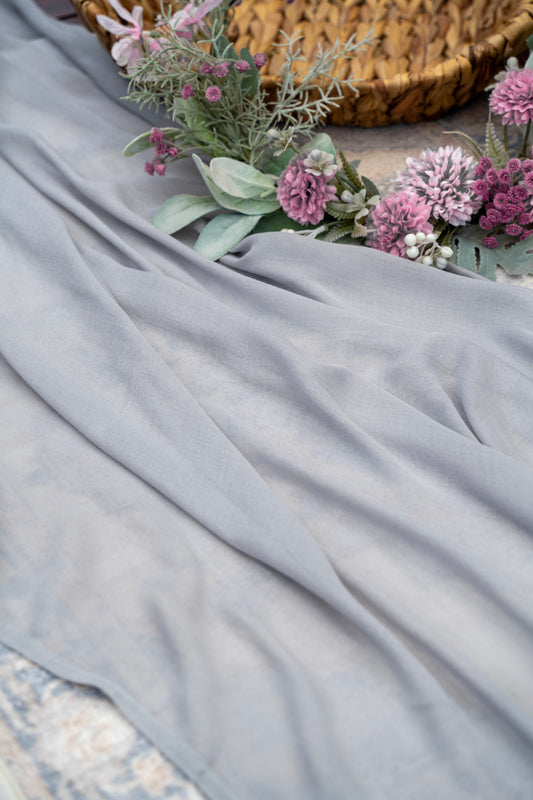 Gray fabric with a woven basket and pink flowers in the background