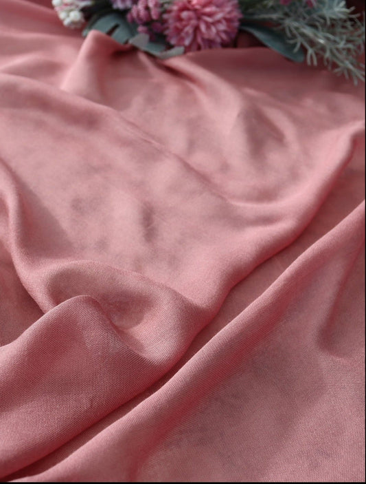 Pink fabric with a floral arrangement on a textured surface