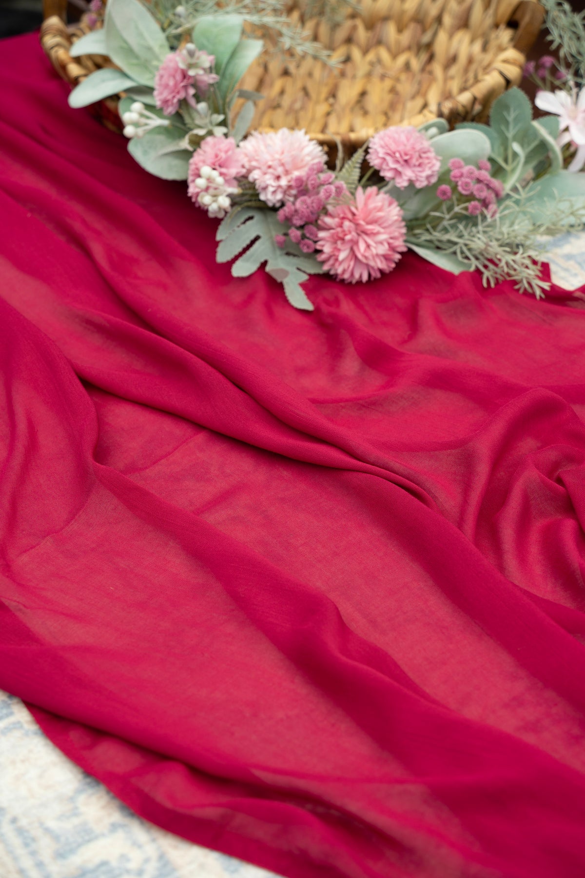 Red fabric with a floral arrangement on a textured surface