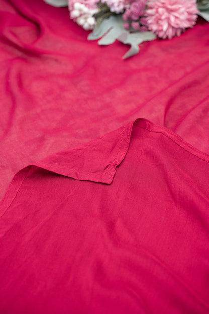 Red fabric with a floral arrangement in the background