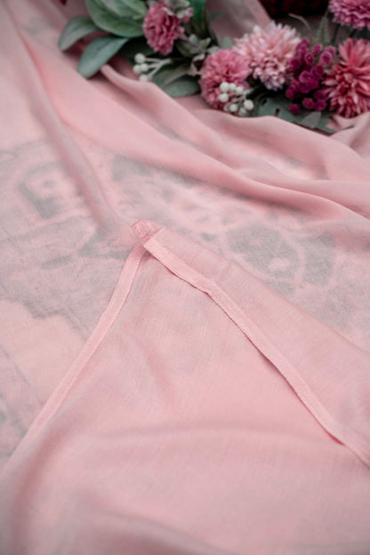 Pink fabric with floral arrangement in the background