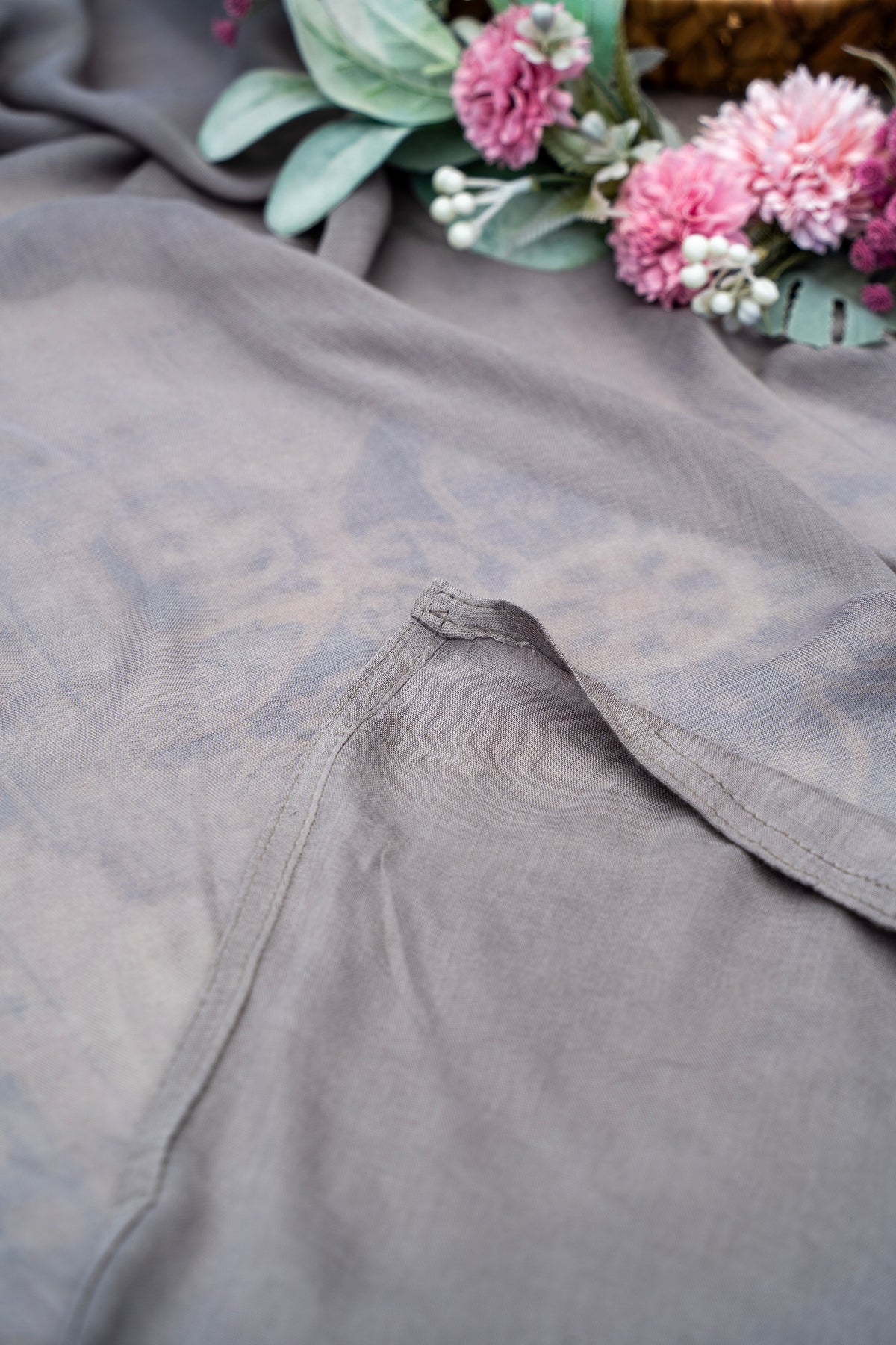Gray fabric with floral arrangement on a textured surface