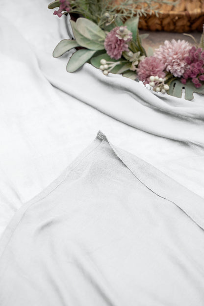 White fabric with a floral arrangement on a textured surface.