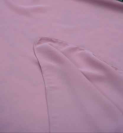 Close-up of pink satin fabric with a floral arrangement on top