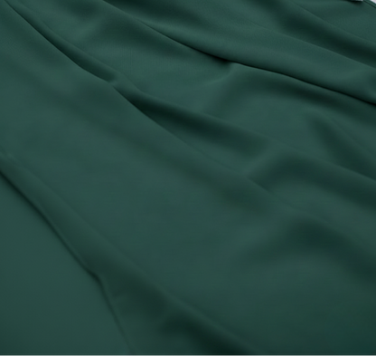 Dark green fabric with pink flowers and greenery on a textured surface