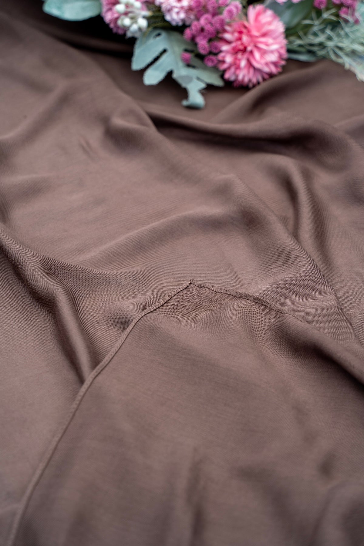 Brown fabric with a floral arrangement in the top left corner
