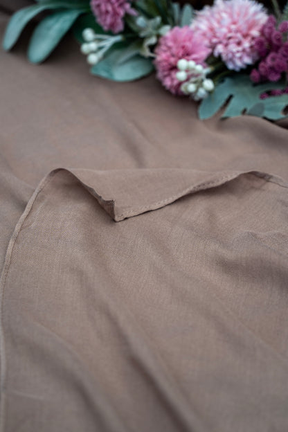 Brown fabric with a floral arrangement in the background