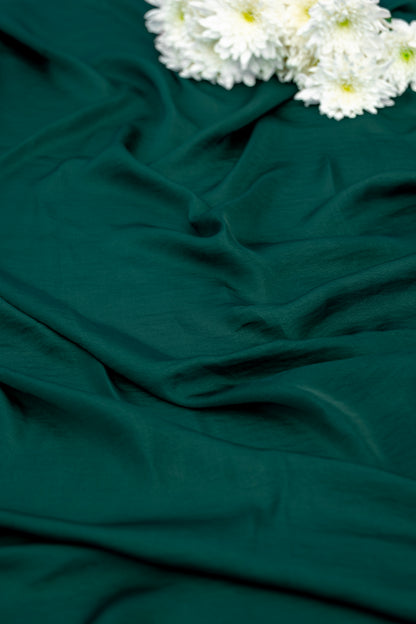 Dark green draped fabric with white flowers placed in the top right corner.